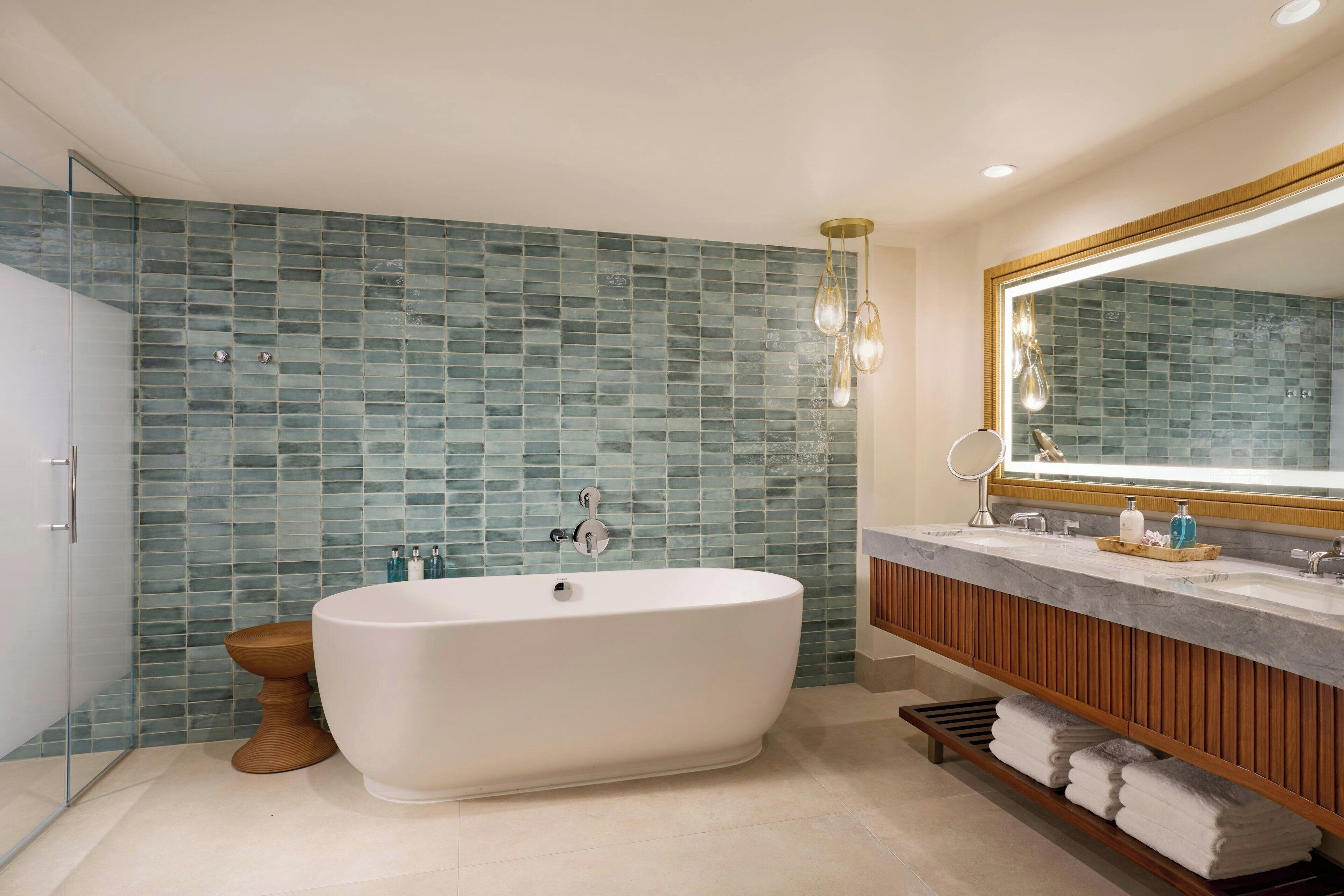 A modern bathroom with a freestanding bathtub, a wooden vanity, and a large mirror.