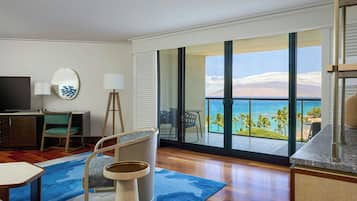 A hotel room with a large balcony, a TV, a desk, and a chair.