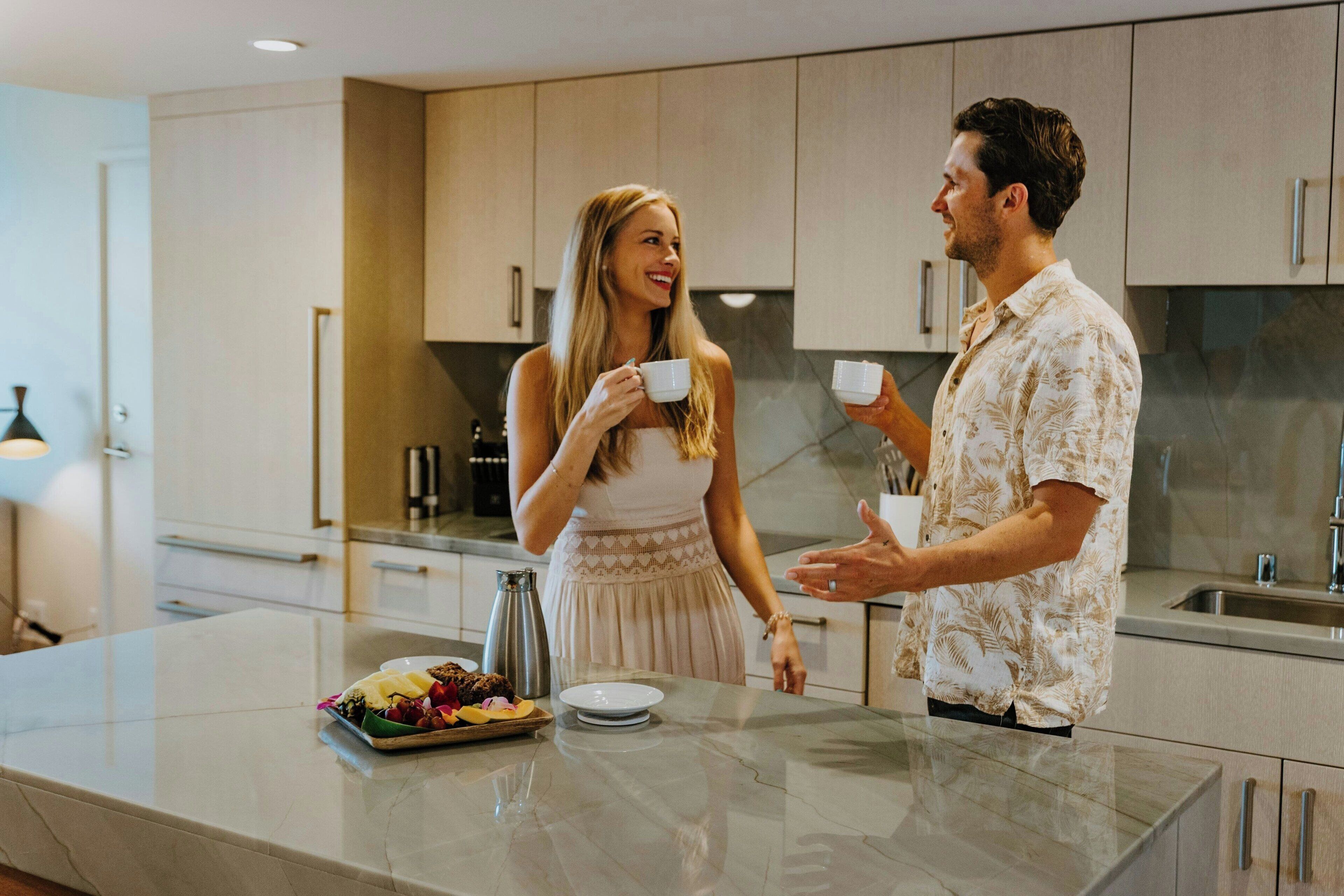 A modern kitchen with a marble countertop, stainless steel appliances, and wooden cabinets.