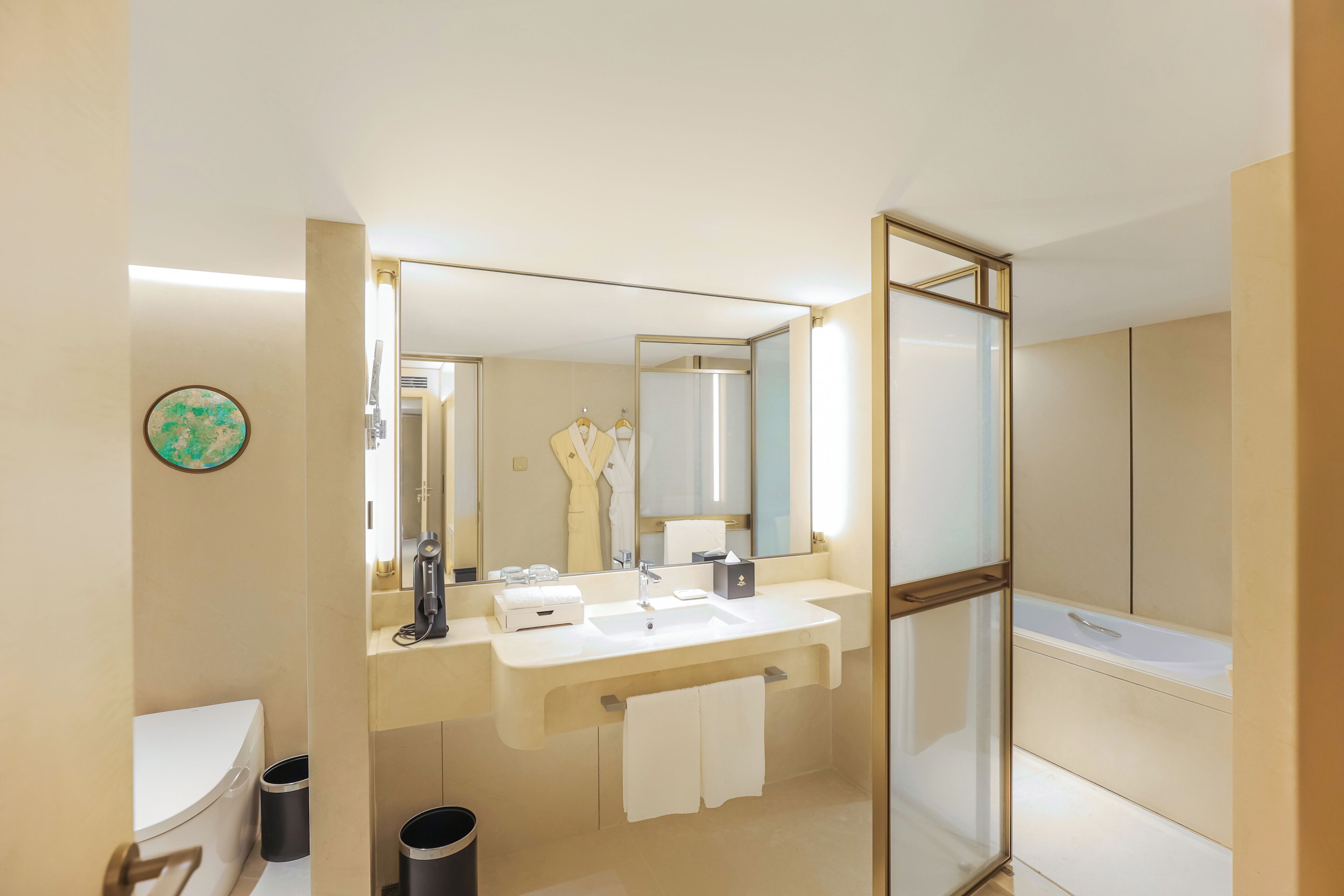 Un baño moderno con un espejo grande, un lavabo, un inodoro y una zona de ducha.