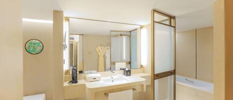 A modern bathroom with a large mirror, a sink, a toilet, and a shower area.