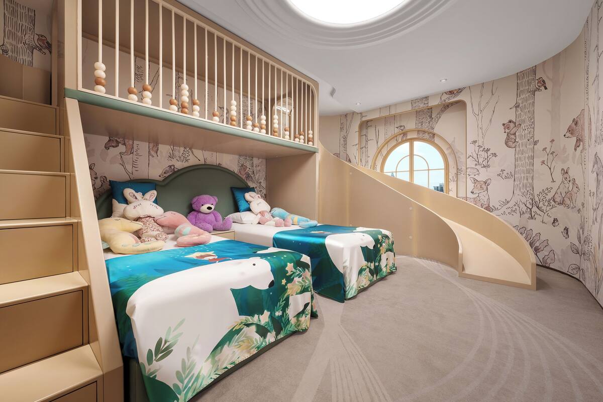 Une chambre d’enfant avec des lits superposés, un escalier et un papier peint sur le thème de la forêt.