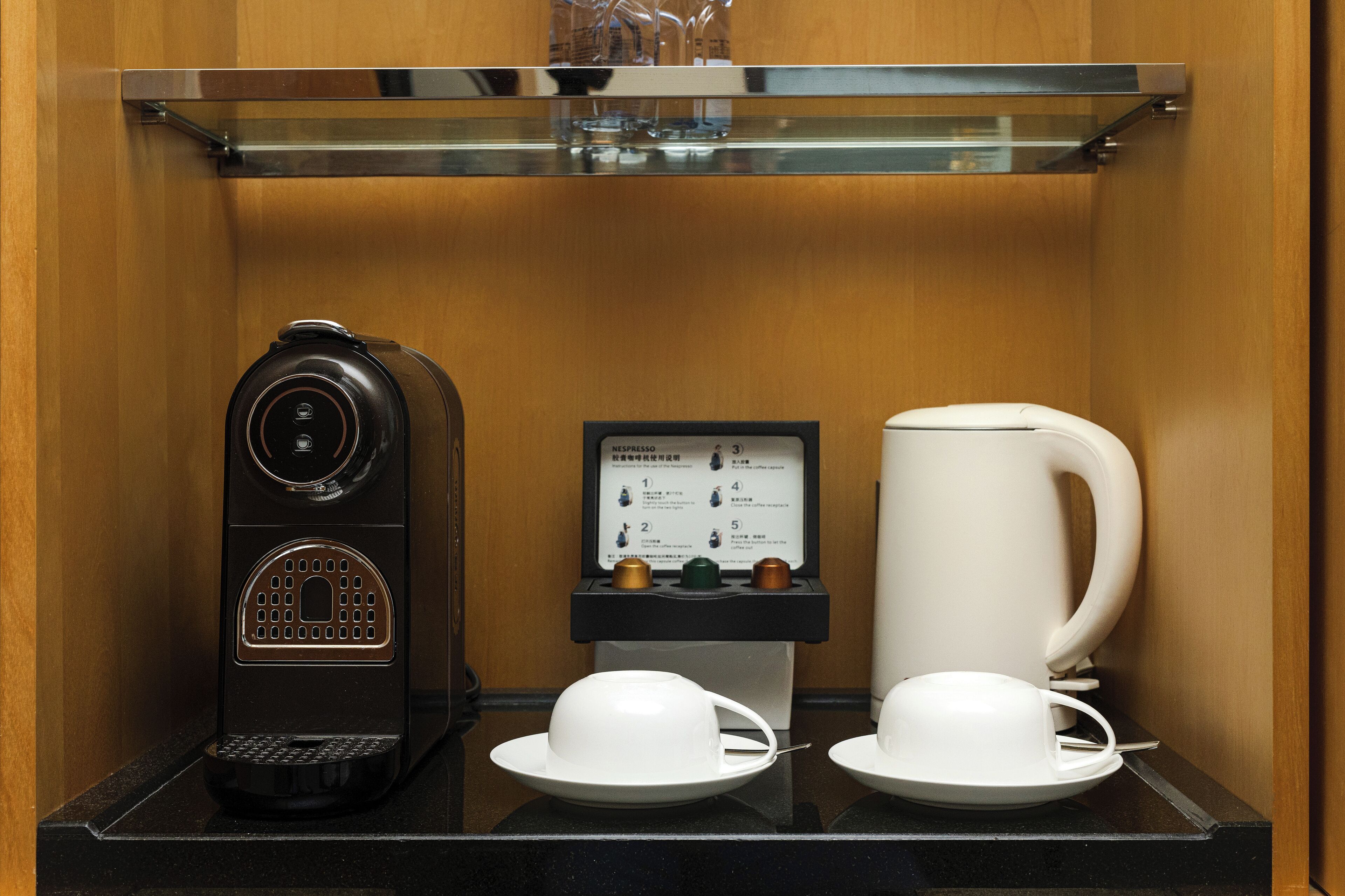 A coffee machine, a menu board, and a coffee pot on a counter.