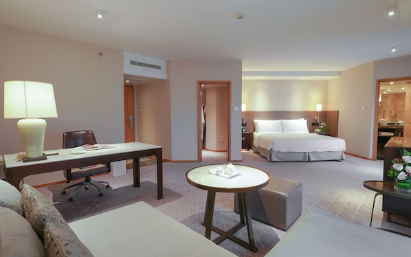 A hotel room with a bed, a desk, a chair, a small table, and a sofa. - Jinling Hotel Nanjing (Nanjing)