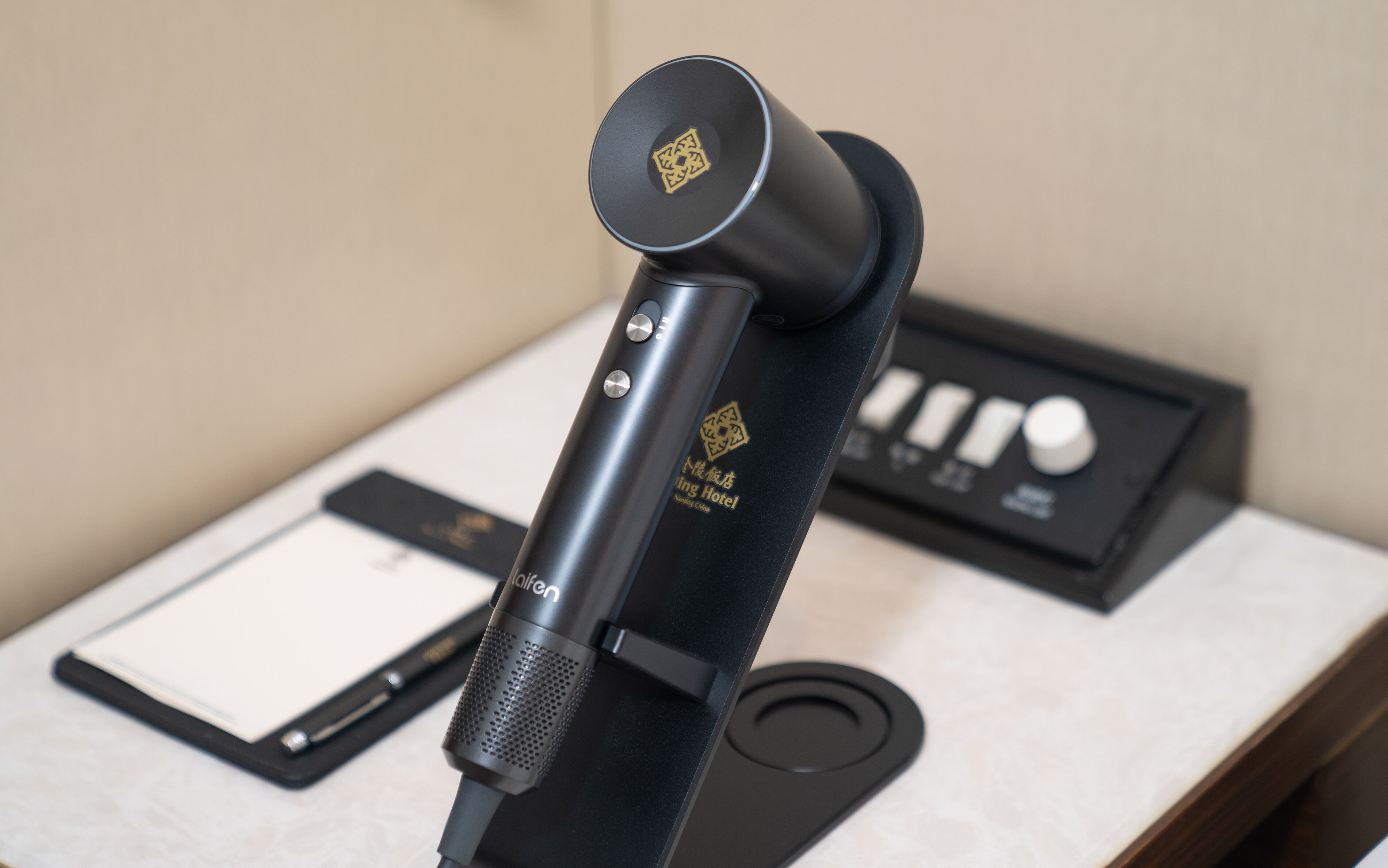 Un microphone sur un pied, avec une étiquette indiquant « Hôtel Shing ».