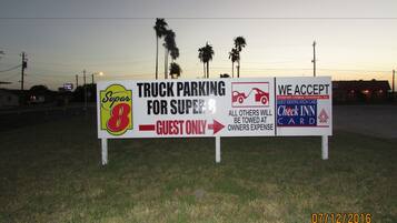A sign indicating truck parking for Super 8 guests only, with a warning that all others will be towed at the owner's expense.