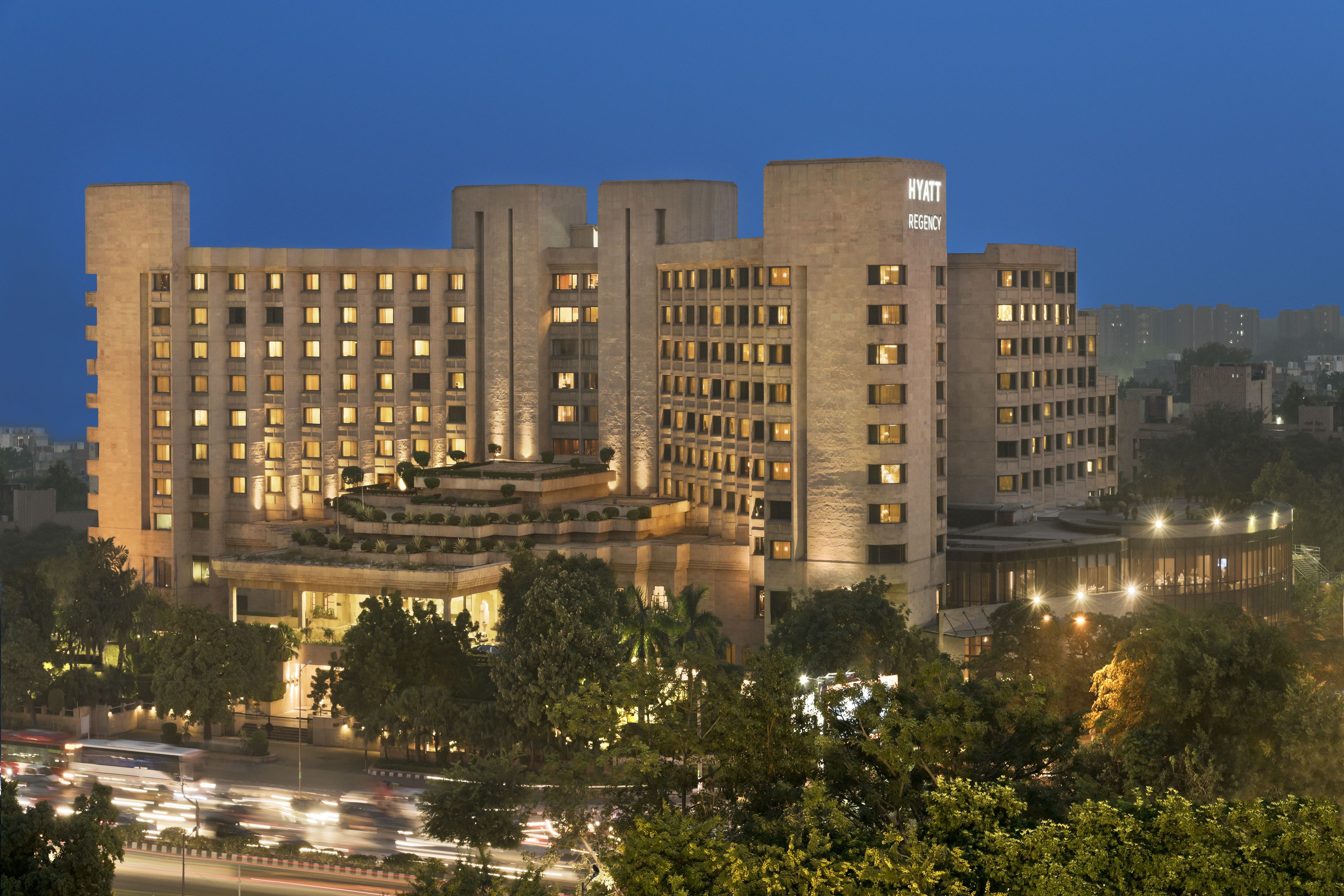 A large, multi-story hotel with a prominent entrance and a landscaped terrace.