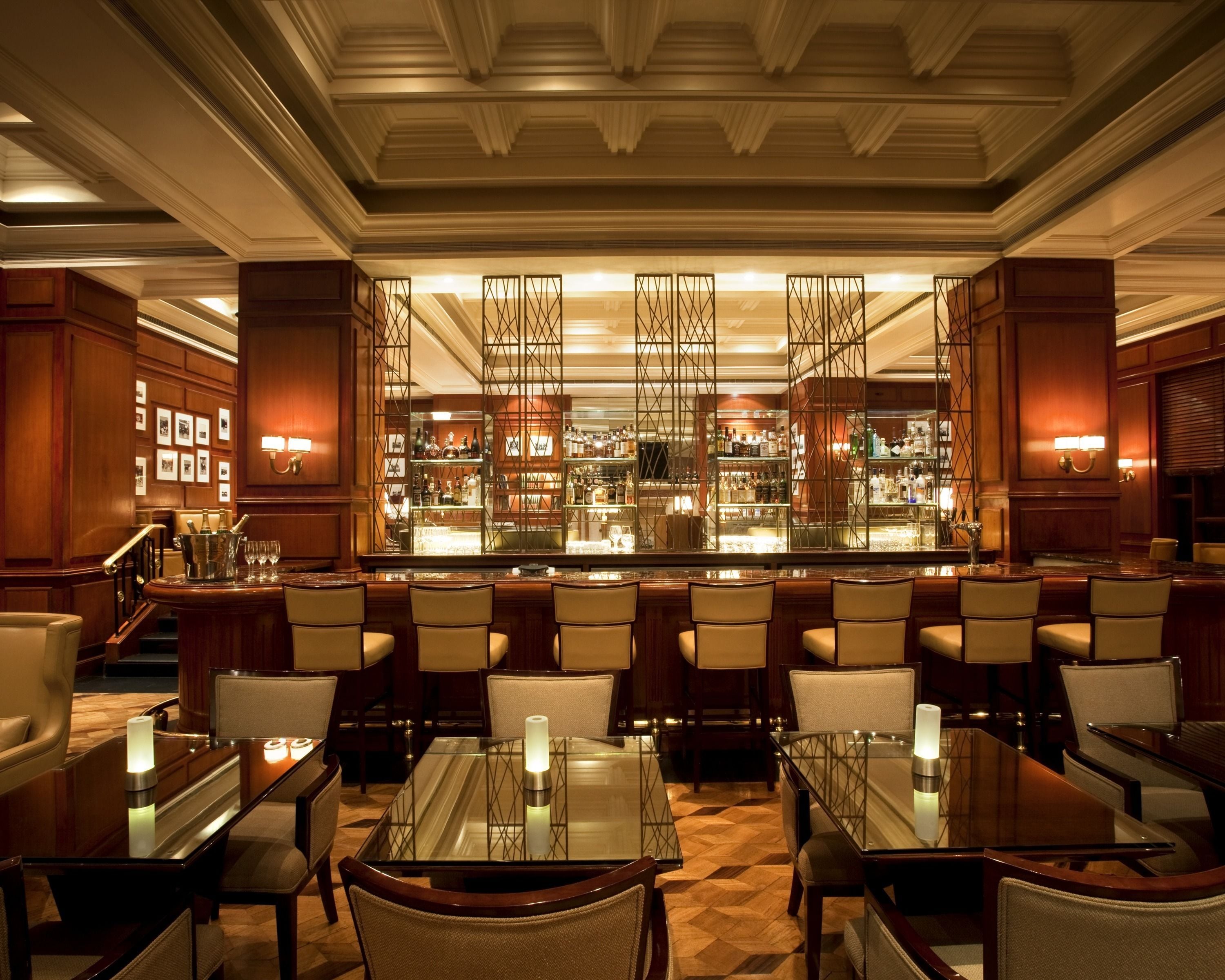 A bar area with a long counter, multiple seating arrangements, and a decorative partition.