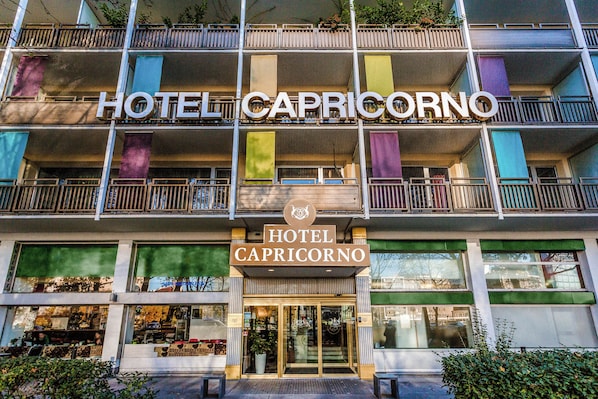 Un hotel con un letrero que dice 'HOTEL CAPRICORNO' y un balcón con barandillas.