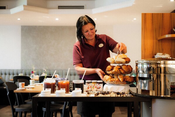 Una mesa de buffet con una variedad de alimentos y bebidas.