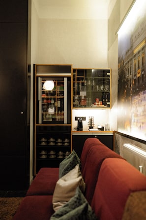 A cozy room with a red sofa, a glass cabinet with kitchenware, and a framed picture on the wall.