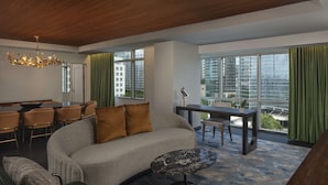 A modern living room with a sofa, a dining area, and large windows offering city views. - Hyatt Centric Midtown Atlanta (Atlanta)
