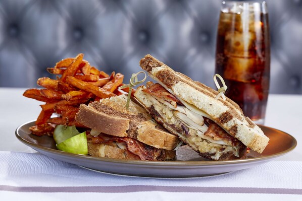 A plate with a sandwich, fries, and a drink.