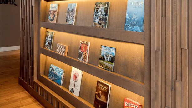 A wall with a wooden panel design and a framed display of books. - Hyatt Centric Midtown Atlanta (Atlanta)