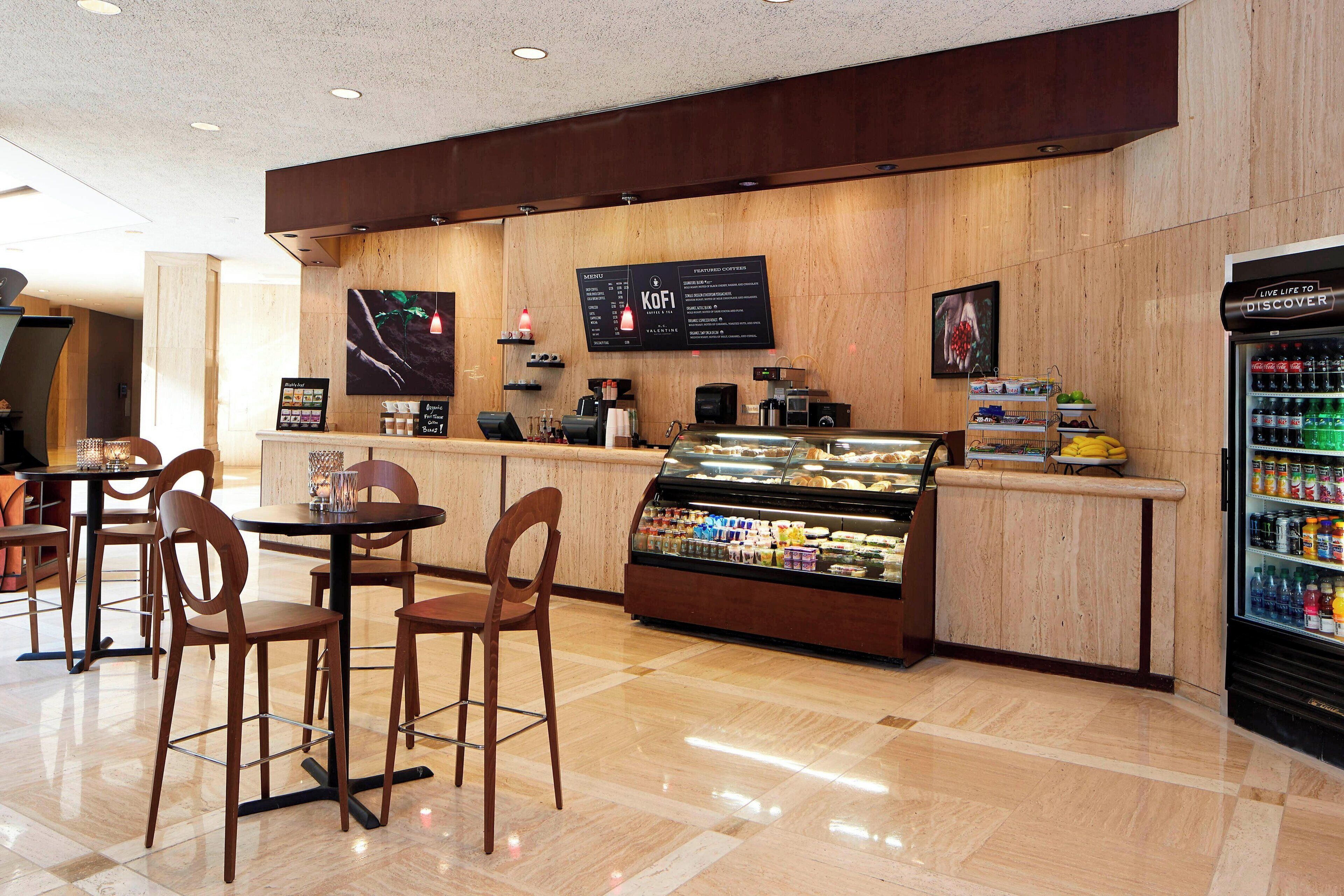 A cafe with wooden walls, a display case with pastries, and a beverage refrigerator.