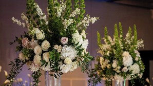 A banquet hall with tables set for a formal event, featuring tall vases with floral arrangements and candle centerpieces. - Renaissance Atlanta Waverly Hotel & Convention Center (Atlanta)