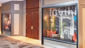 A hotel lobby with a patterned carpet, a seating area with cushions, and a large window with a cityscape view. - Renaissance Atlanta Waverly Hotel & Convention Center (Atlanta)