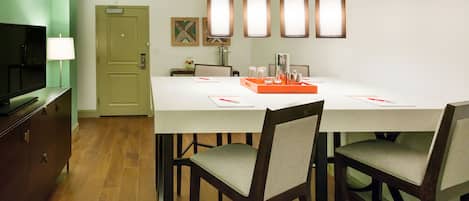 Un comedor con una mesa, sillas, un televisor y una puerta.