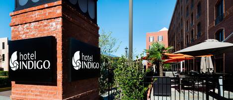 Ein Hotelschild mit dem Schriftzug 'hotel INDIGO' und einer Backsteinstruktur.