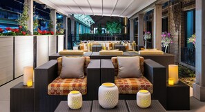 Relax in a, covered patio with comfortable sofas and ambient lanterns.