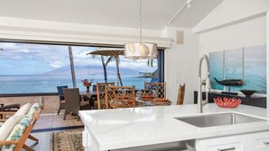 Una cocina moderna con un amplio ventanal con vistas al océano.