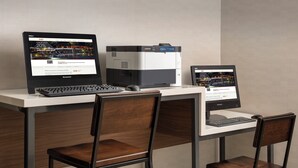 Despatx modern amb dos monitors, un teclat i dues cadires de fusta.