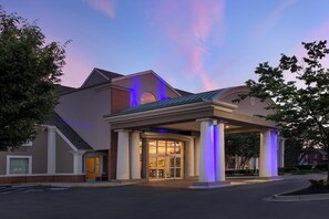 A hotel with a covered entrance, large columns, and a brick facade.