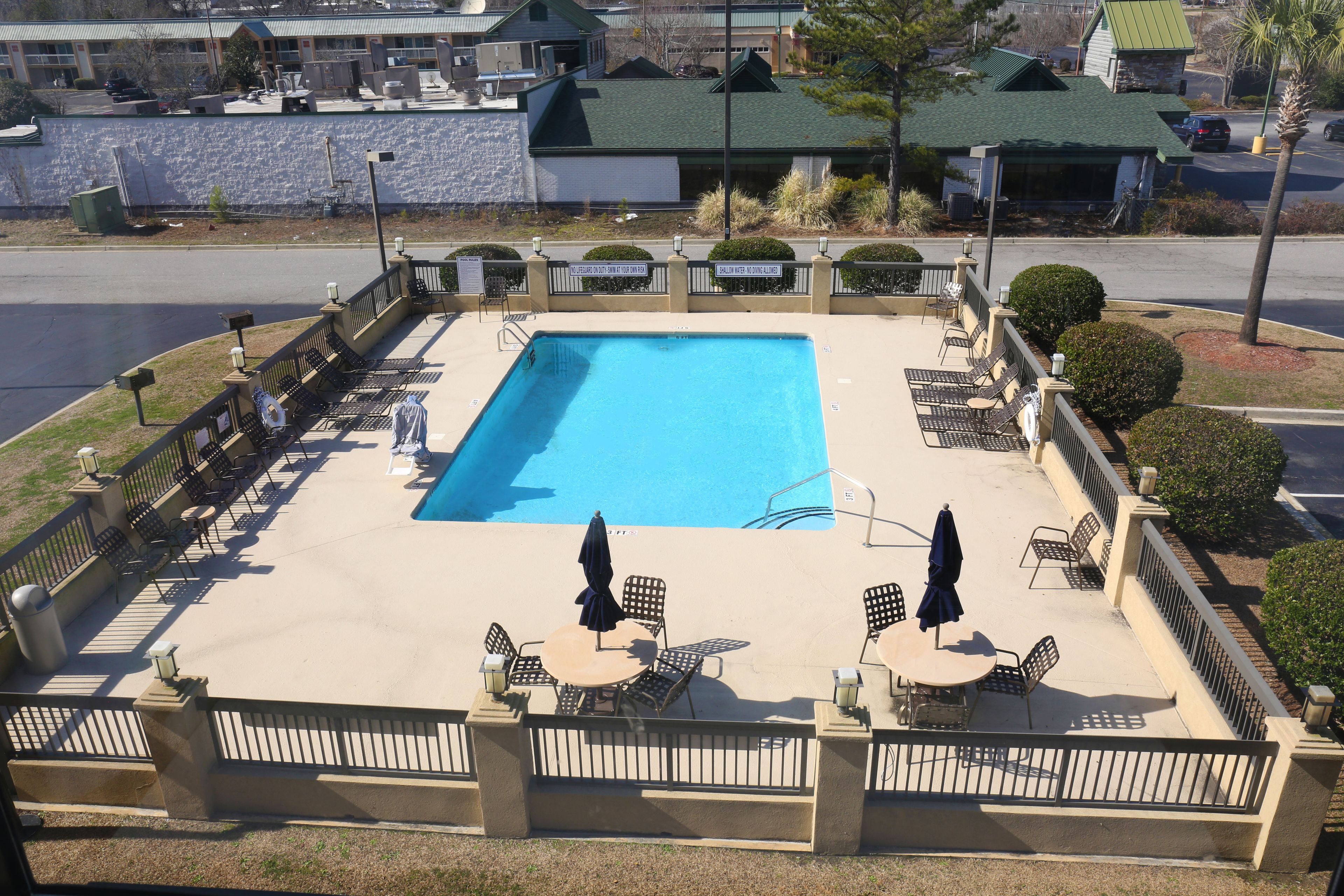 En säsongsöppen utomhuspool och solstolar