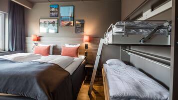 Habitación de hotel con dos camas, una litera, cabecero de madera y lámparas fijadas a la pared.