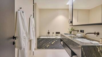 Un baño moderno con un espejo grande, dos lavamanos y un tocador de mármol.