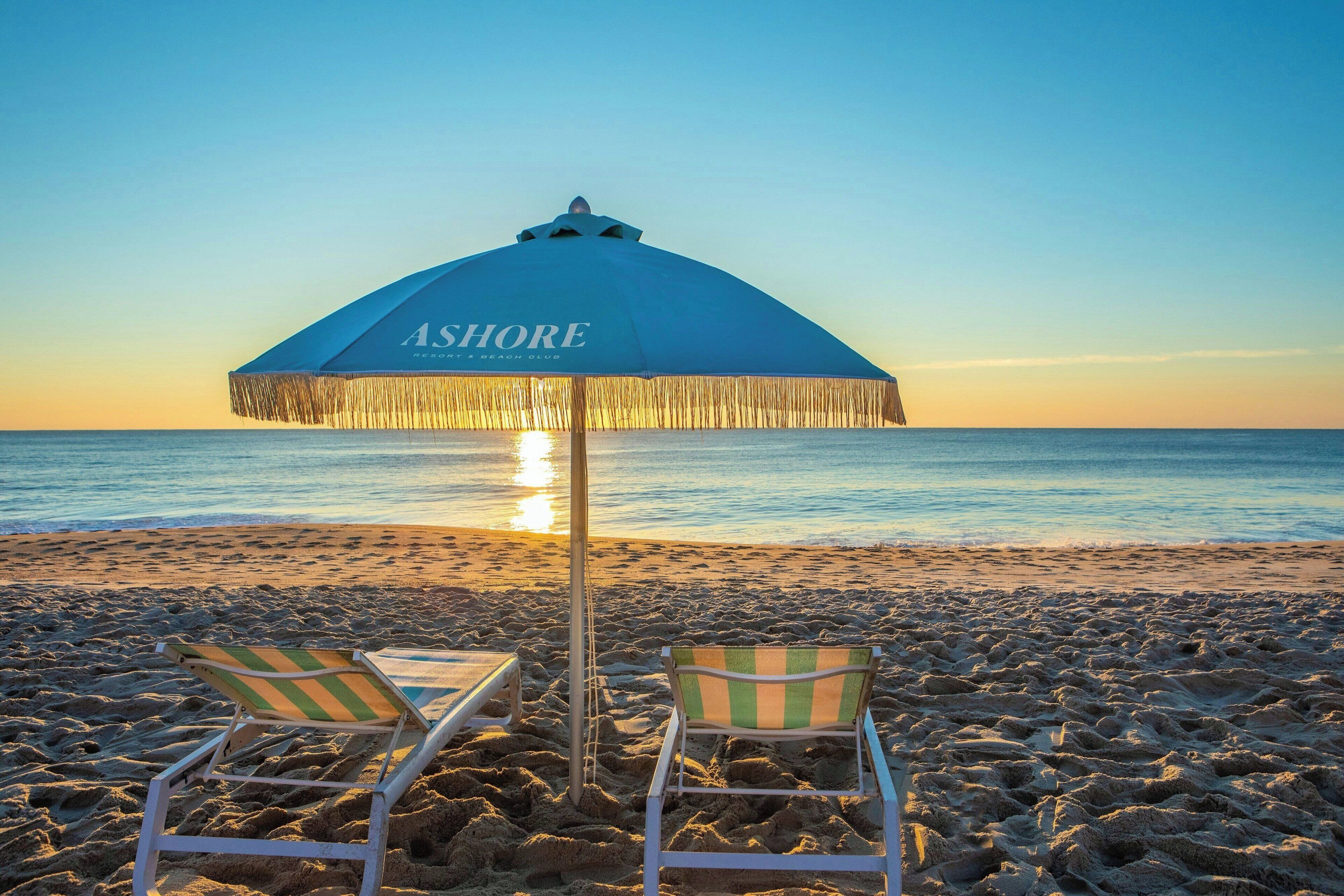 A beach umbrella labeled 'ASHORE' with two striped beach chairs.