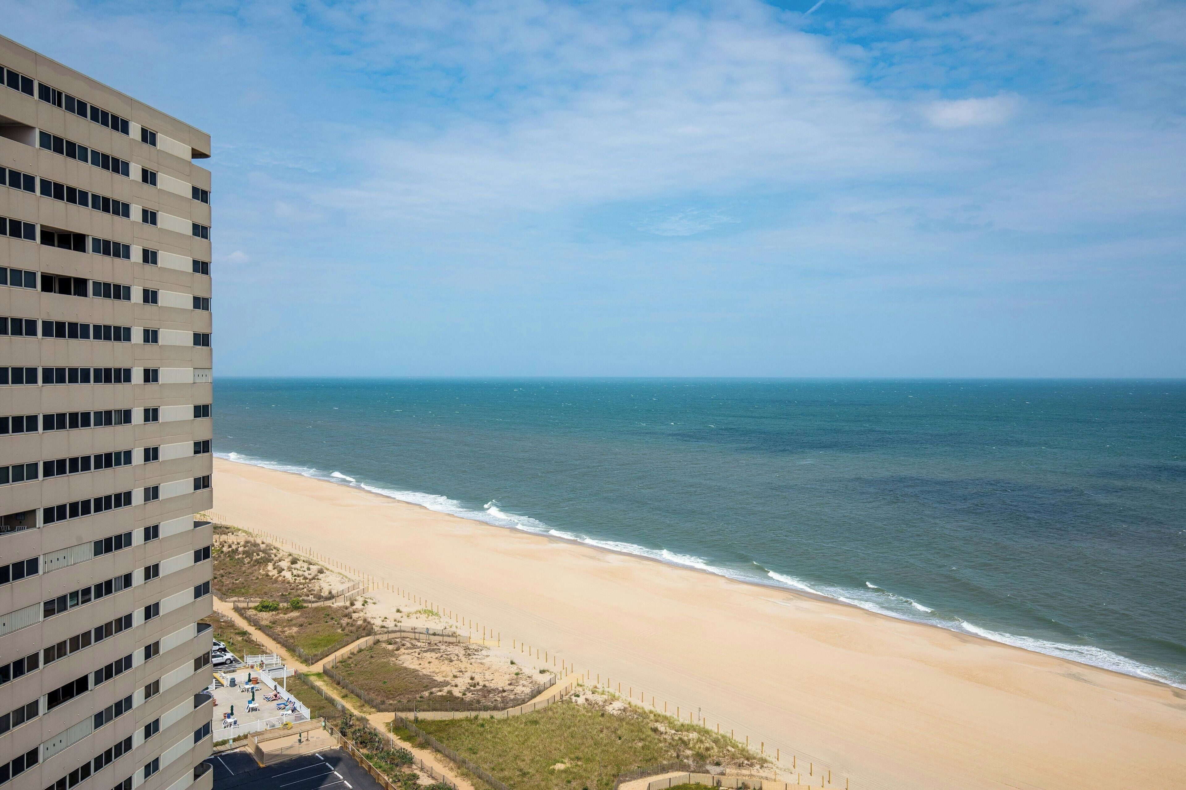 Na praia, espreguiçadeiras, guarda-sóis, toalhas de praia 