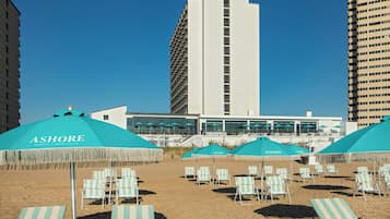 A beach with sun umbrellas labeled 'ASHORE' and lounge chairs.