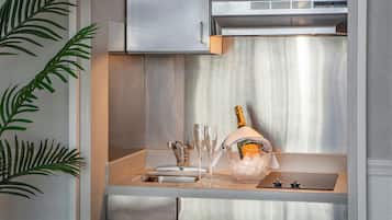 A modern kitchen with stainless steel appliances, a sink, and a decorative plant.