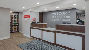 A hotel reception area with a welcome sign, a treats display, and a key stone state sign. - Hampton Inn by Hilton Philadelphia / Willow Grove (Willow Grove)