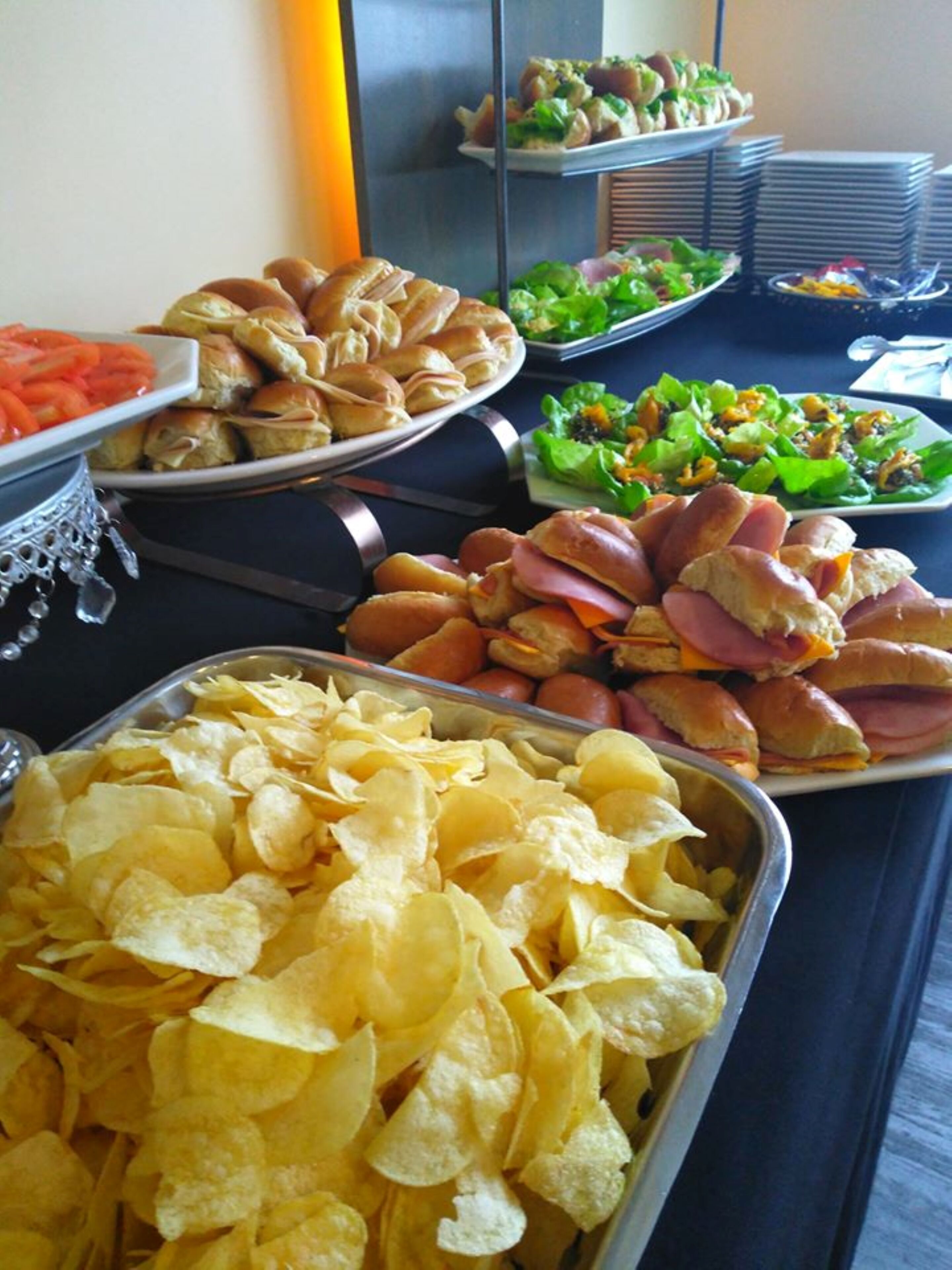 Un bufé con diversas opciones de comida, como sándwiches, ensaladas y papas fritas.