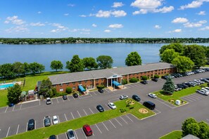 A hotel with a swimming pool, parking lot, and a view of a lake. - Lakeside Inn (Wakefield)