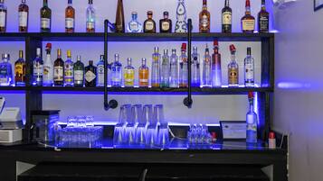 A bar with multiple shelves of liquor bottles and glasses.