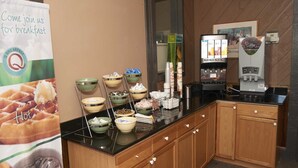 A breakfast buffet area with various food items and a coffee machine. - Quality Inn Bourne - Cape Cod (Buzzards Bay)