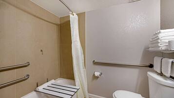 A bathroom with a bathtub, a toilet, a shower curtain, and a towel rack.