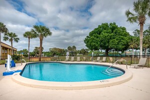 Una piscina al aire libre, sillones reclinables de piscina