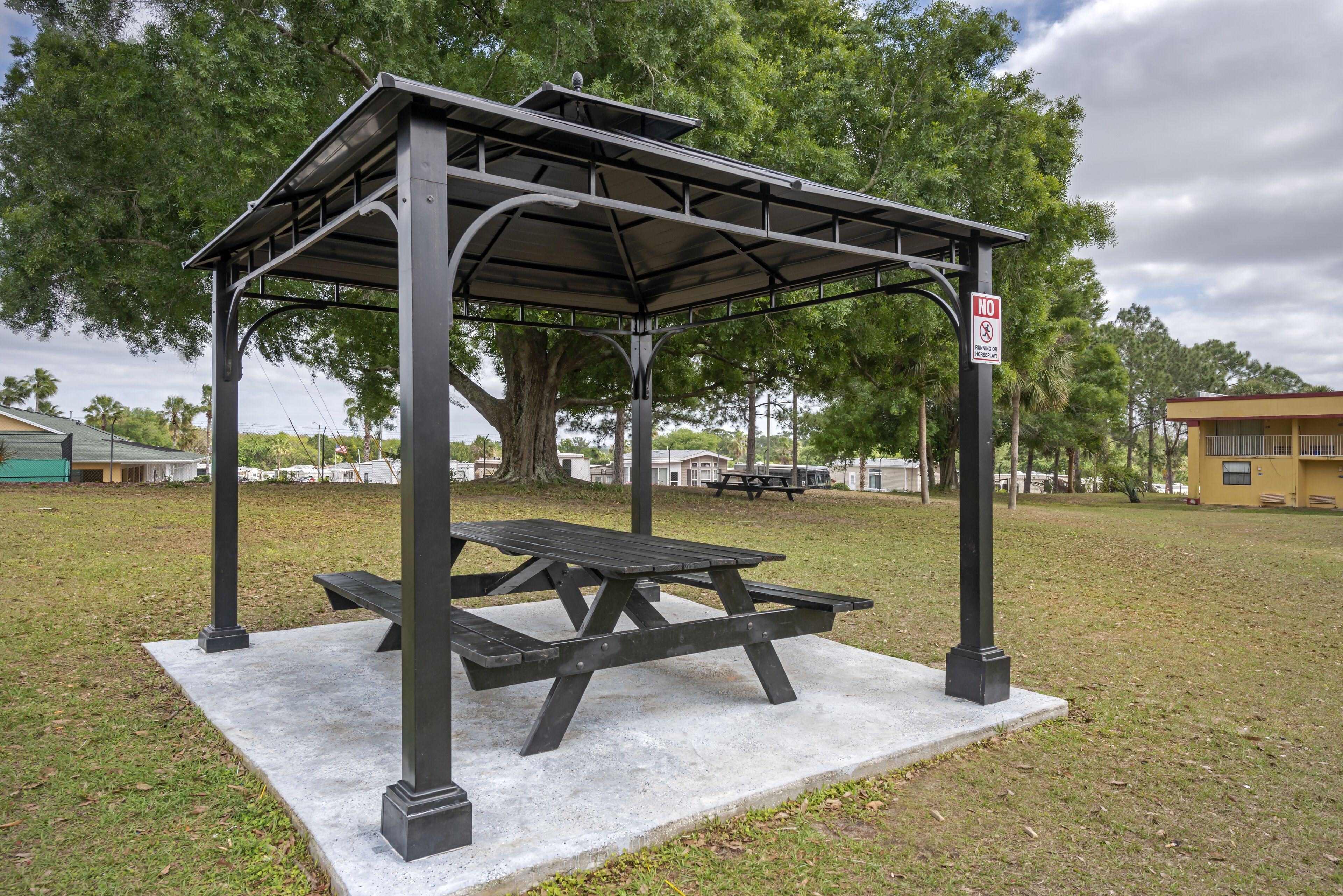 A gazebo with a picnic table in a grassy area.