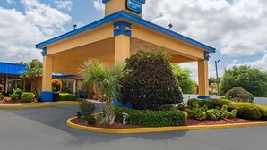A Rodeway Inn with a covered entrance, a parking lot, and well-maintained landscaping. - Rodeway Inn Clermont North (Clermont)