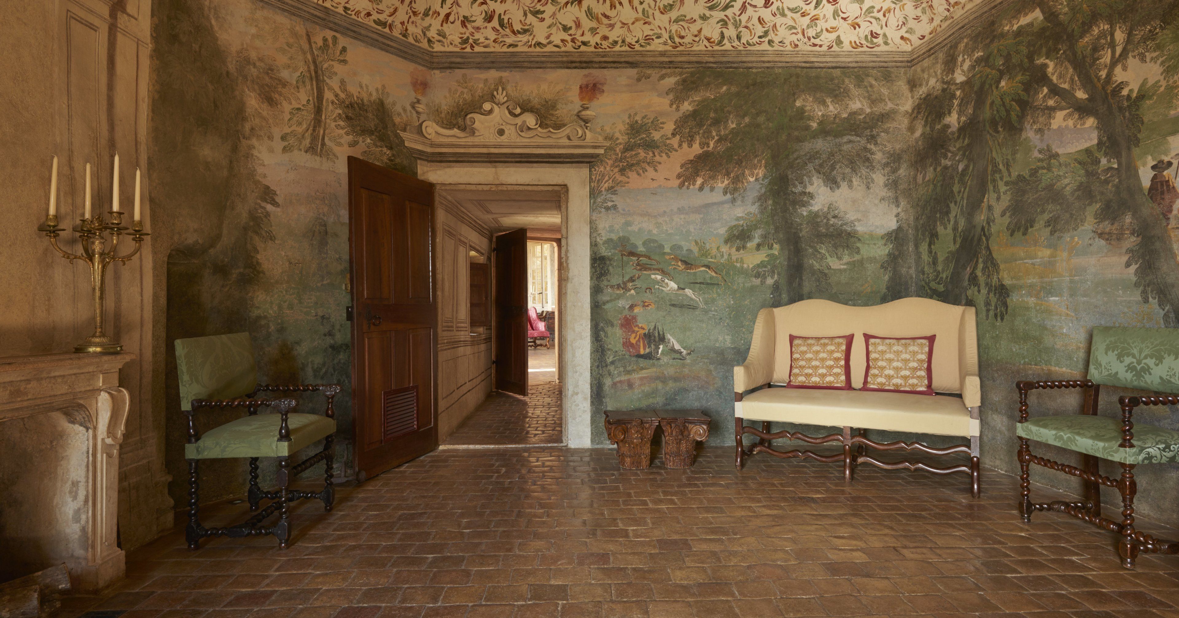 A room with a wooden floor, a bench, and a chair.