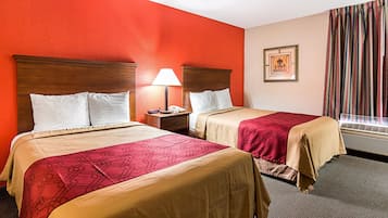 Una habitación de hotel con dos camas, una mesita de noche con una lámpara, un cuadro en la pared y una ventana con cortinas.
