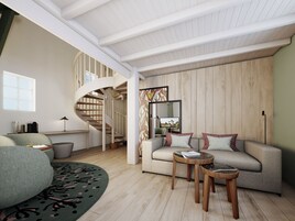 Una sala moderna con una escalera espiral, un conjunto de sofás y una mesa de centro redonda.