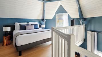 Une chambre à coucher avec un lit, des tables de chevet, une fenêtre et une vue sur l’extérieur.