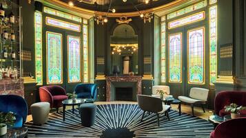A luxurious room with a fireplace, elegant chairs, and a patterned rug.