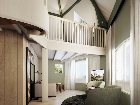 A spacious living area with a high ceiling, a balcony, and large windows providing natural light.