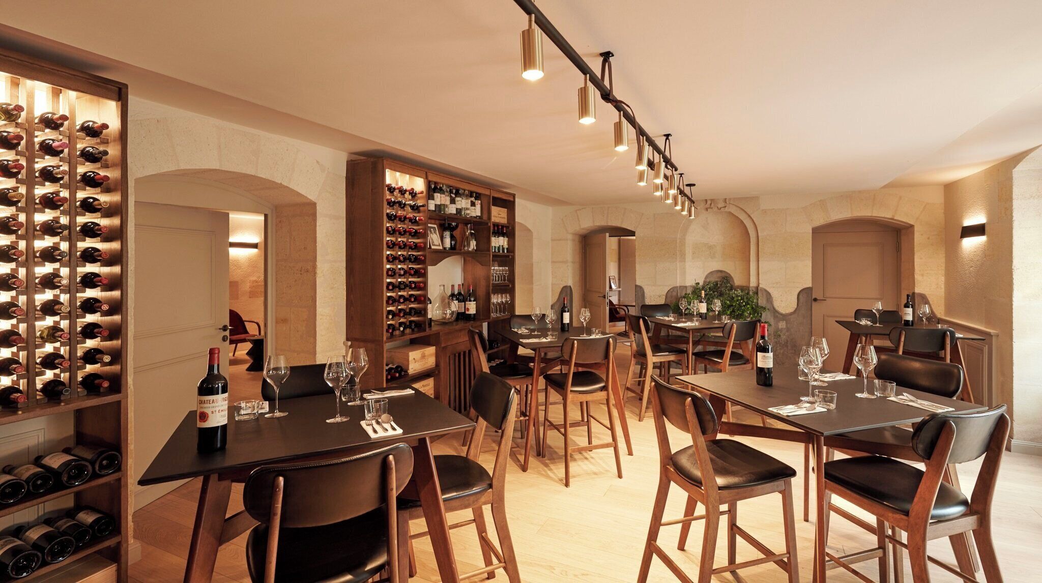 A wine cellar with multiple wine racks and tables set up for dining.